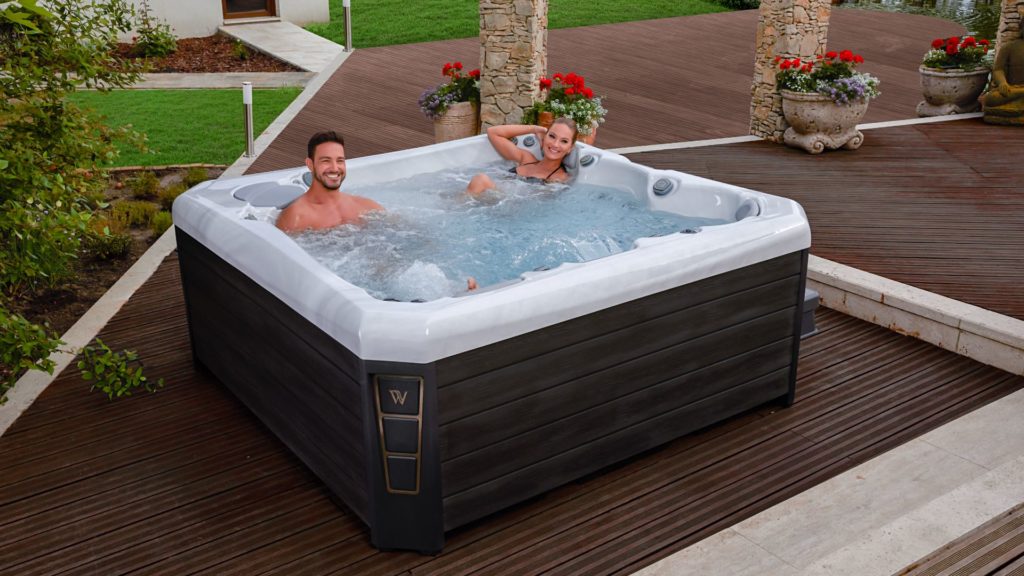 Couple soaking in a high-end hot tub by Wellis Spas | High-end vs entry-level hot tubs