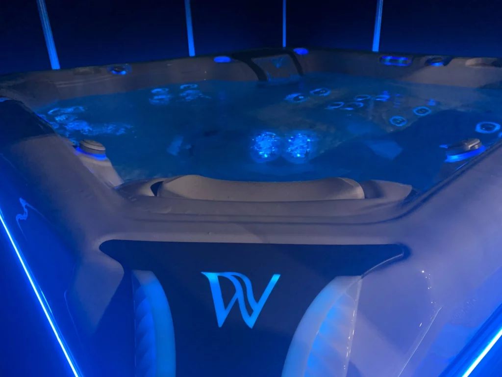 Close up on a Wellis hot tub interior illuminated bu blue light. In chromotherapy, blue light is associated with positive mental wellness effects.